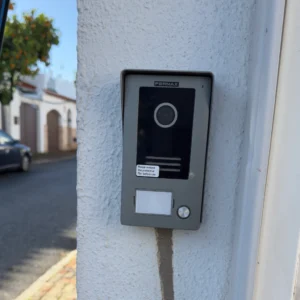 Videoportero moderno instalado en pared exterior blanca