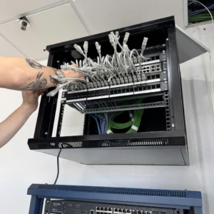 Técnico conectando cables en rack de red